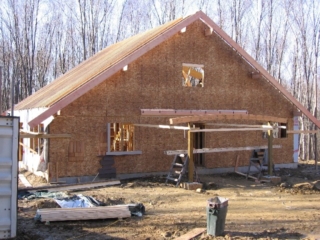 Looking Northwest; with the help of the crane again today, the East fly rafters and curved pergola beam are in place