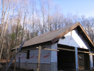 Looking Southeast; garage roof complete; trim stained Oxford Brown