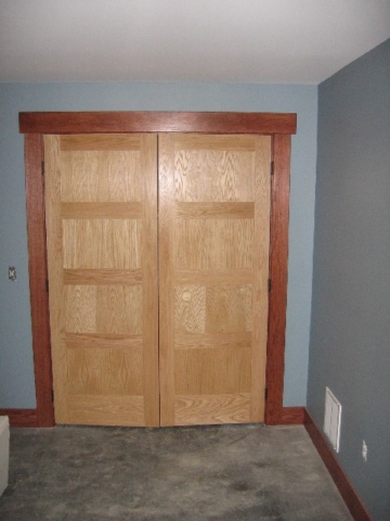 Looking East at lower level bedroom oak closet doors