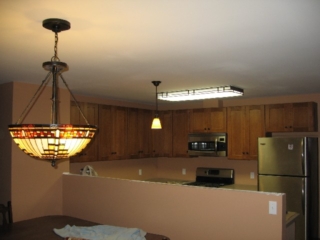 Looking Northwest from dining room into kitchen; not that all three of these lights will all be on at once, but they are finally all up; appliances got moved in last Wednesday; backsplash to go in Monday